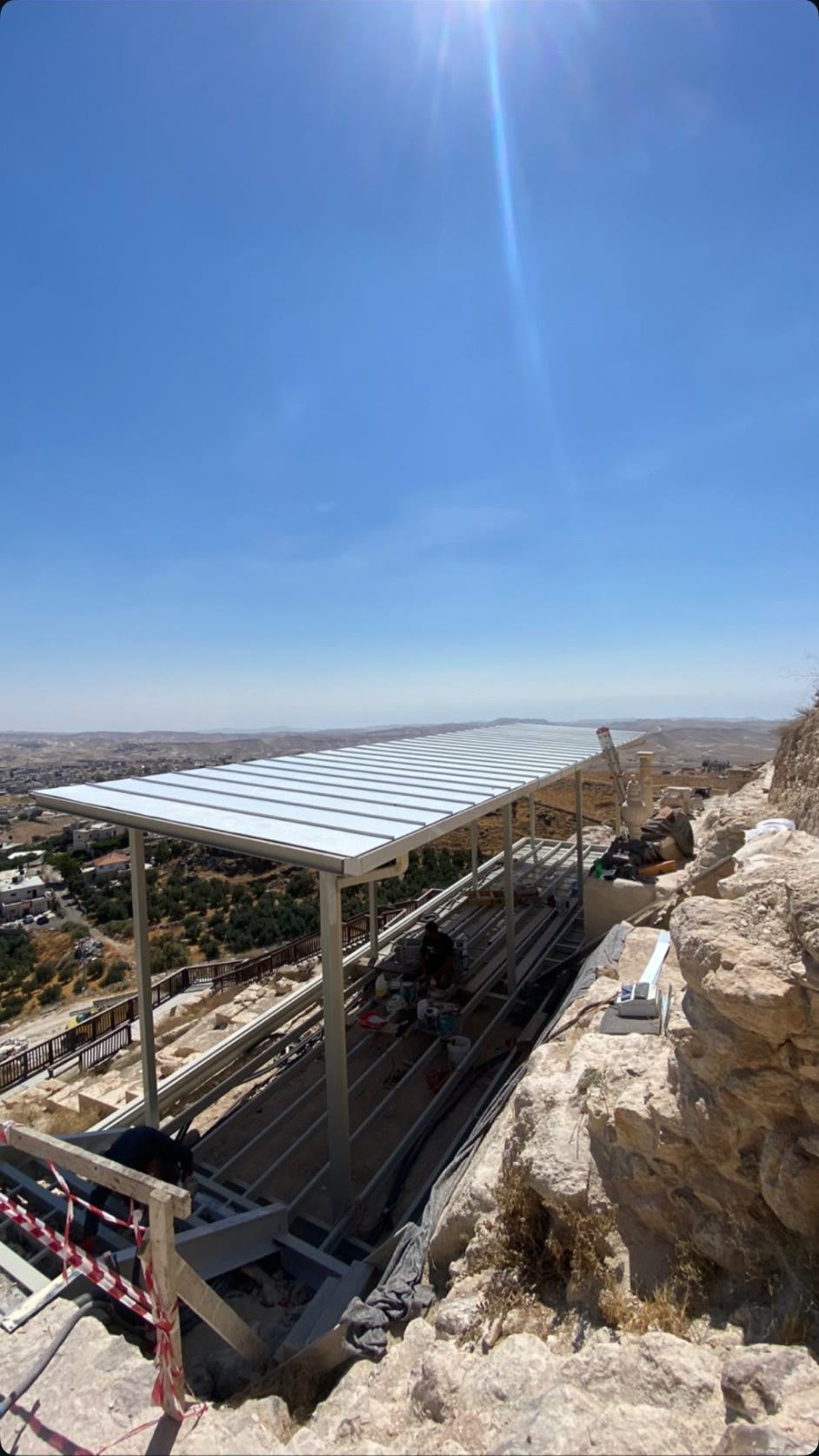 סככת מתכת בקצה מצוק מעל נוף מדברי